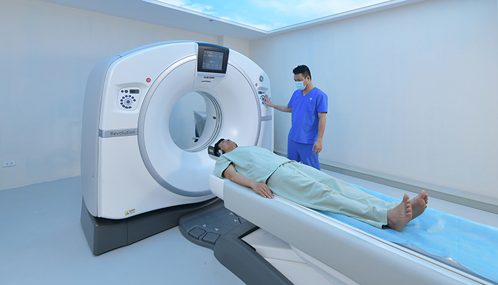 Ký thuật viên hướng dẫn khách hàng nằm đúng vị trí khi thực hiện chụp CT