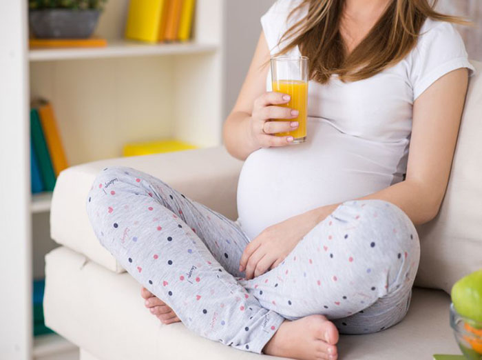 Bà bầu uống nước ép cam để bổ sung vitamin C tăng cường hệ miễn dịch cho bà bầu 3 tháng đầu